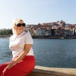 Woman enjoying a sunny day by the river in Porto, Portugal, wearing sunglasses